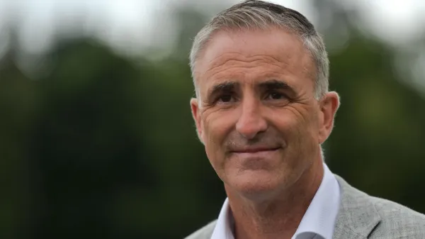 Chris Andrews wearing a grey suit, he has grey hair