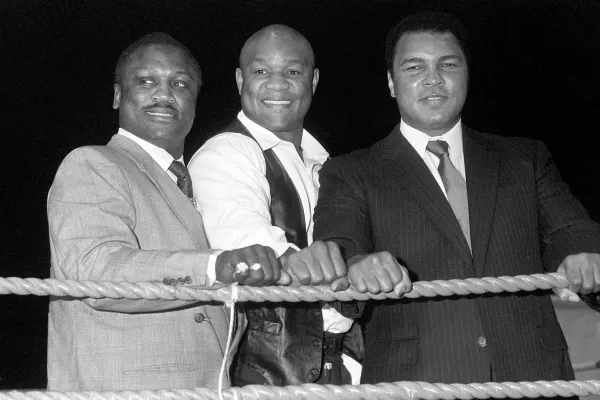 Frazier and Ali with George Foreman (centre), one of their shared opponents, in 1989 (PA)