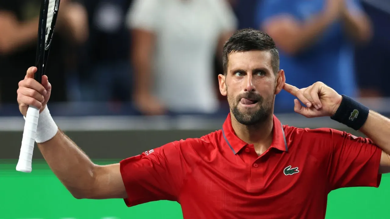 Novak Djokovic points to his ear as the crowd applauds him taking the second set to level the match