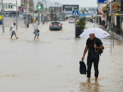 People walk along a flooded street in Ibiza on September 30, 2025 (Vicent MARI)