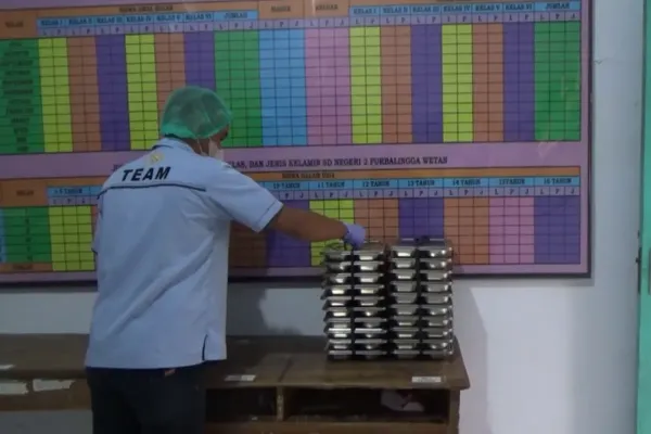 Petugas SPPG Purbalingga Wetan menata tumpukan ompreng berisi menu makan siang bergizi sebelum dibagikan ke siswa penerima manfaat