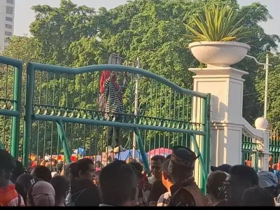 Seorang ibu nekat memanjat pagar pintu timur masuk Monumen Nasional (Monas), Jakarta, Minggu (5/10/2025) untuk menyaksikan perayaan HUT ke-80 TNI.