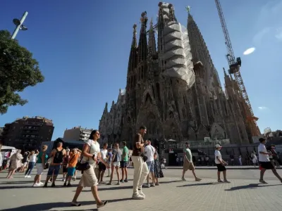 Tourists walk past the Sagrada Familia basilica in Barcelona on August 2, 2025 (Manaure QUINTERO)