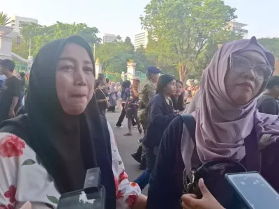 Yayah (kiri) dan Siti Aisyah (kanan) mendatangi kawasan Monas, Jakarta, Minggu (5/10/2025) untuk melihat penampilan anaknya dalam kegiatan HUT ke-80 TNI.